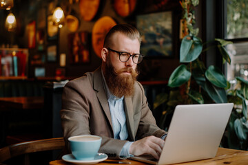 Stylish Entrepreneur Working on Laptop in Cozy Coffee Shop