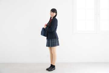 使いやすい白背景でカメラ目線の女子高生の全身