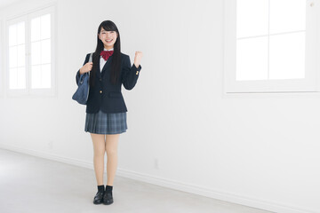 使いやすい白背景で笑顔でガッツポーズの女子高生 全身