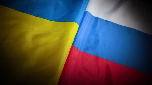 Dynamic turn of Ukraine and Russia national flags with vignette