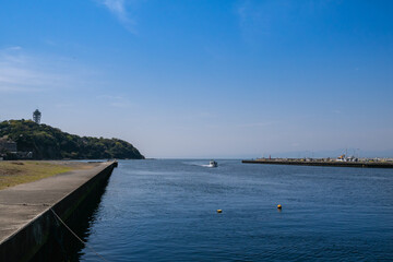 Fototapeta na wymiar 神奈川県の有名な観光地の江ノ島。青空と海と船の風景。