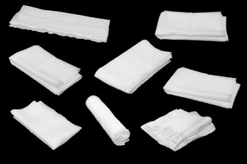 Wet tissues folded in various shapes, black background.