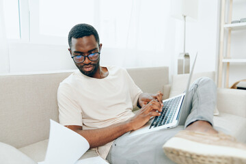 Smiling African American Freelancer Working on Laptop in a Modern Living Room
