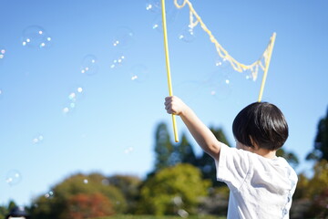 シャボン玉発生器で遊ぶ少年 / Boy playing with soap bubble generator