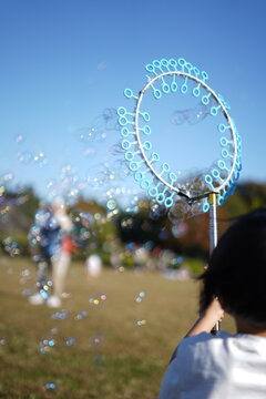 風車泡機で遊ぶ少年 / Boy playing with windmill foam machine