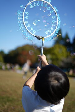 風車泡機で遊ぶ子供 / Child playing with windmill foam machine
