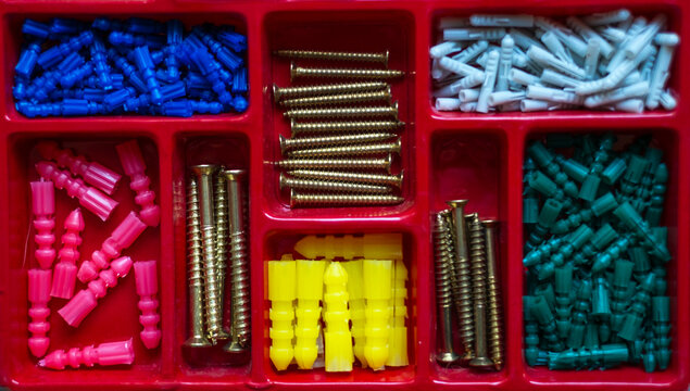 Organizador rojo de taquetes y tornillos de diferentes tama&ntilde;os y colores