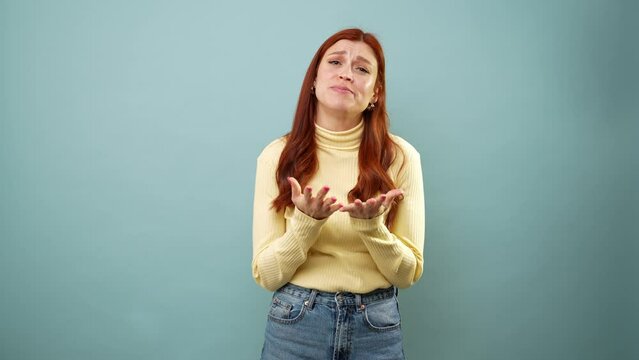 Woman with red hair in a studio pleading with a sad face and really asking for a favor
