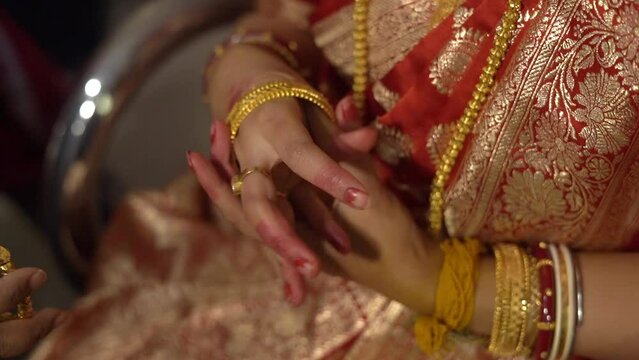 Closeup shot of an Indian Hindu bride wearing her bangles in her wedding. Blurred background.