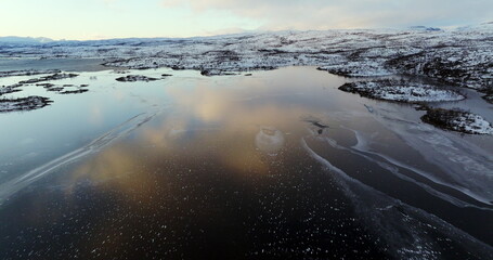Winter's Brush: Aerial View of a Partially Frozen Lake in Norway
