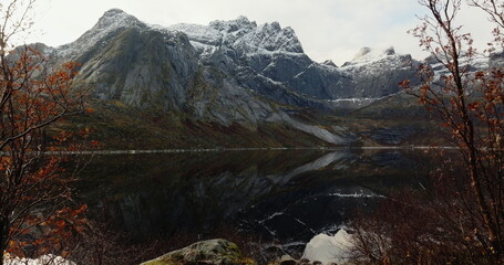 Fototapeta na wymiar Autumn's Reflection: Serene Lake and Snow-Capped Peaks in Lofoten