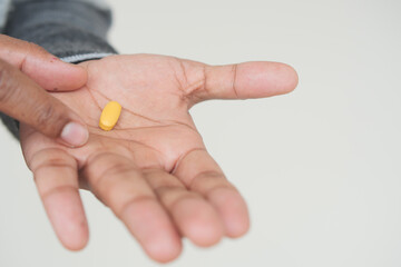 Close up of man hand holding pills with copy space 