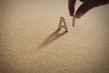 AI wood word on compressed or corkboard with human's finger at I letter..