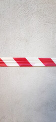 Danger red/white tape on white wall with copy space