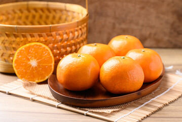 Mandarin orange fruit on wooden plate, Tropical fruit
