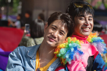 Two gay men join in the fun at the Pride parade, celebration of Pride Month, LGBTQ concept, selective focus