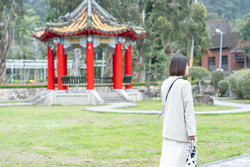 台湾台北市士林区の大きな公園で２０代の若い台湾人女性が散歩する風景 A young Taiwanese woman in her 20s taking a walk in a big park in Shilin District, Taipei City, Taiwan