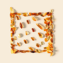 Nature gemstone amber stones with glare shadows, yellow orange colored on beige background. Natural...