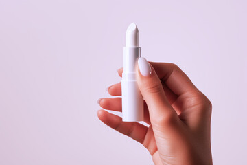 Hand holding white lipstick isolated on white background, beauty