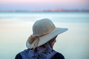 Dame au bord de mer portant un chapeau