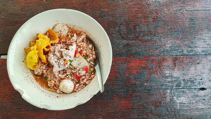 Tom Yum Noodle with minced pork and meat balls, crispy wontons, selective focus. Famous Thai soup noodles