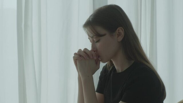 A young woman praying - cold blue tone / early morning