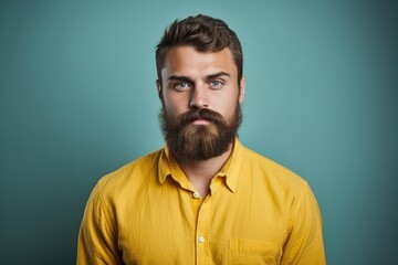 Obraz premium A photo of a man with a beard confidently wearing a bright yellow shirt.