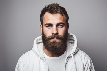 Fototapeta premium A man with a beard is seen wearing a white hoodie.