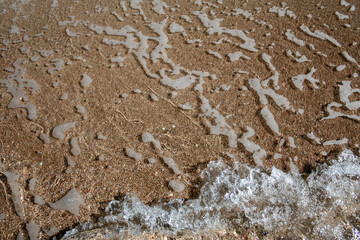 Abstract view with sea waves texture. Foam of sea waves in color abstraction. The structure of the sea surf in shallow water is specially tinted in different colors. View from above.