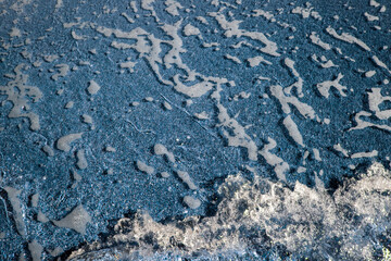 Abstract view with sea waves texture. Foam of sea waves in color abstraction. The structure of the sea surf in shallow water is specially tinted in different colors. View from above.