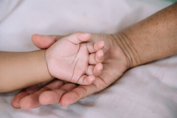 Close up baby hand on mother's hands.