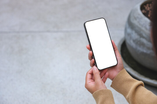 Mockup image of a woman holding mobile phone with blank desktop white screen