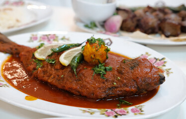 Maragat Zubaidi Fish dish with tomato Sause on a plate. Silver pomflet fish with red Sause traditional Middle Est dish