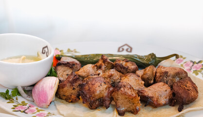 Arabic beef kebab with dipping sauce and onion on white background. Healthy grilled beef kebab.