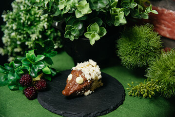 Hedgehog-Shaped Cookie Cake on Slate Plate. A creative hedgehog-shaped dessert made from cookies, condensed milk, and cocoa powder, garnished with white chocolate chips on a slate plate