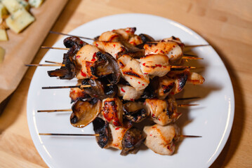 Grilled Chicken and Mushroom Skewers on Plate. Juicy grilled chicken and mushroom skewers served on a white plate, perfect for a delicious appetizer or main dish