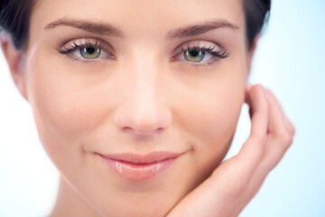 Obraz premium Skincare, facial beauty or portrait of woman in studio isolated on blue background for pride or wellness. Natural results, smile or smooth face of happy model or confident person with shine or glow
