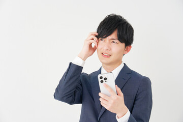 スマートフォンを持って考えるビジネスマン　白背景