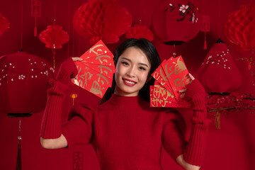 New Year atmosphere, a young Asian woman holding a red envelope against a red background