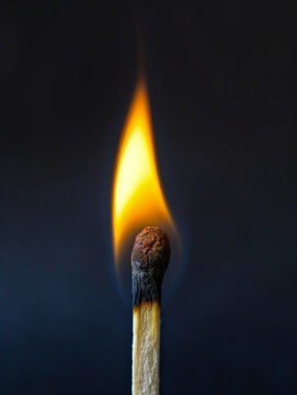 Closeup of a burning match stick on black background