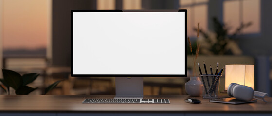 A white-screen computer mockup on a hardwood desk in a modern home office during sunset time.