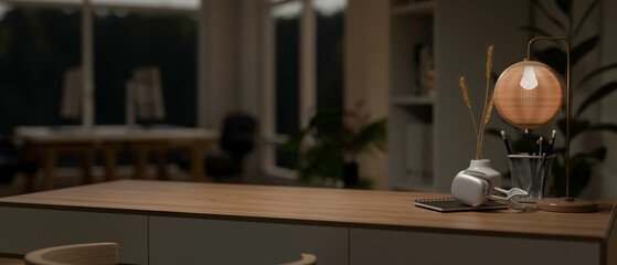 A modern home office at night with a space to display your product on a minimal wooden table.