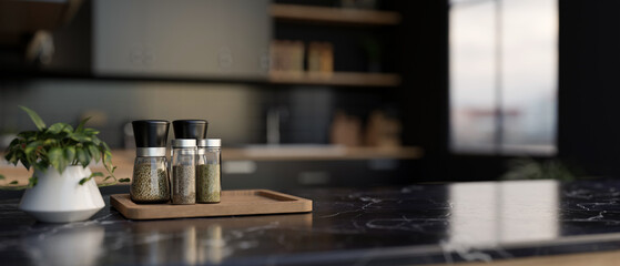 A set of spice bottles on a luxury black marble kitchen countertop in a modern black kitchen.
