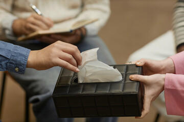 Fototapeta premium Close up of unrecognizable person taking tissue from box during emotional therapy session, copy space