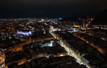 Brasov from above. Winter night aerial photo with this beautiful city from Transylvania, Romania, view to Sfatului Square and Black Church (Piata Sfatului si Biserica Neagra in Romanian language).