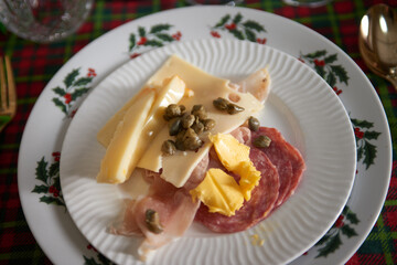 Mouthwatering charcuterie platter featuring gourmet salami, cheese, mortadella, and ham—a delectable first course, a feast for the senses.