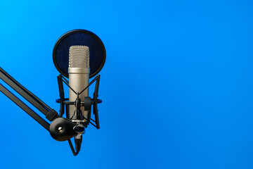 Professional microphone stand over blue studio background