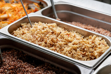 Metal trays with fresh food in a canteen