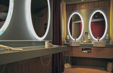 Modern design bathroom with sink, shower, towels and mirror and mosaic tiles in male locker...