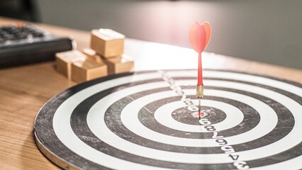 Fototapeta na wymiar Targeting the business concept, Businessman holding a darts aiming at the target center business goal concept - business targeting, focus concept,metaphor to target marketing or target arrow concept.